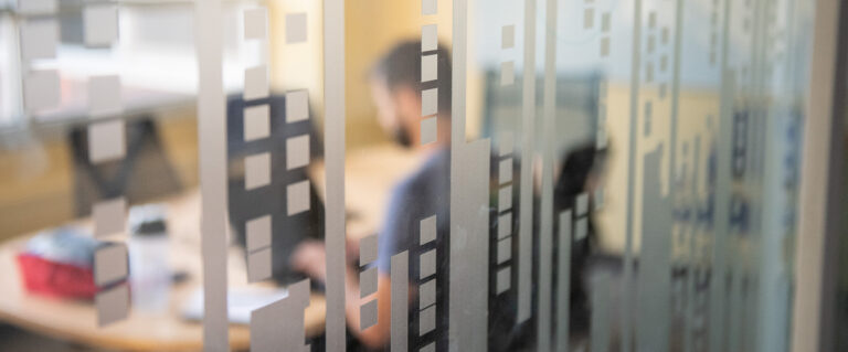 a person working on a computer behind a glass wall